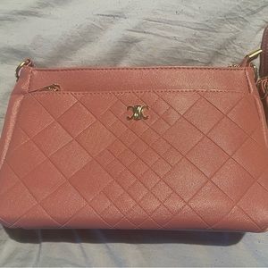 Pink woman's purse with shoulder strap .